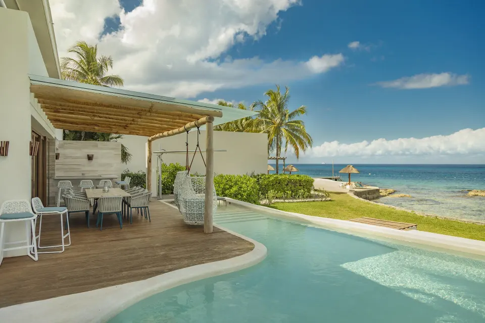 Private villa pool flowing to ocean with pergola dining area at InterContinental Presidente Cozumel Resort Spa
