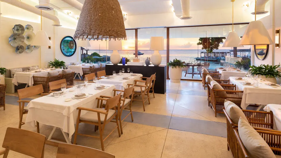 Bright restaurant interior with ocean view and set tables at InterContinental Presidente Cozumel Resort Spa