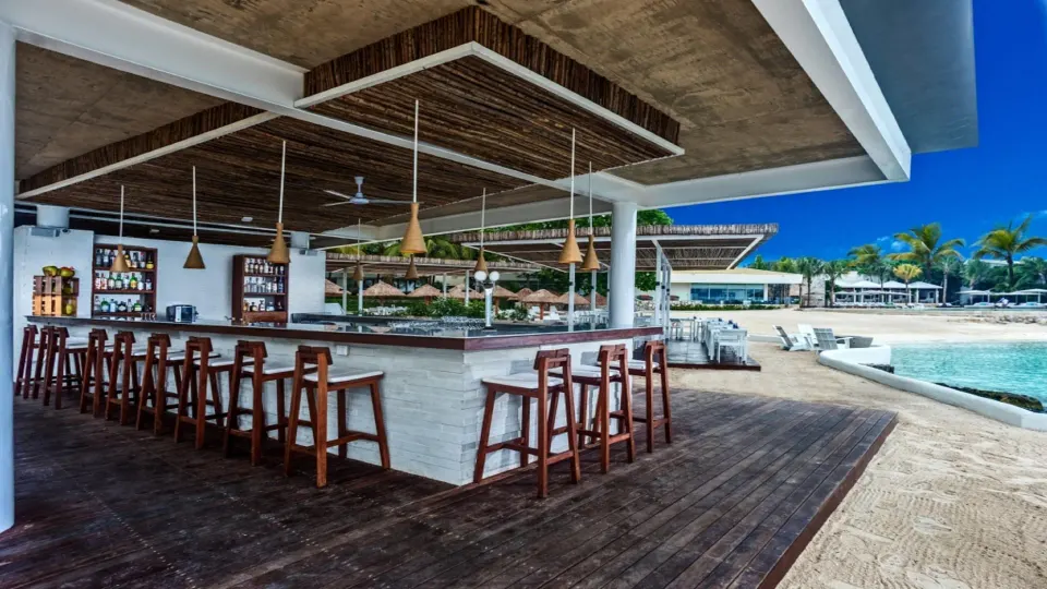 Open-air beachside bar with wooden stools and ocean beyond at InterContinental Presidente Cozumel Resort Spa