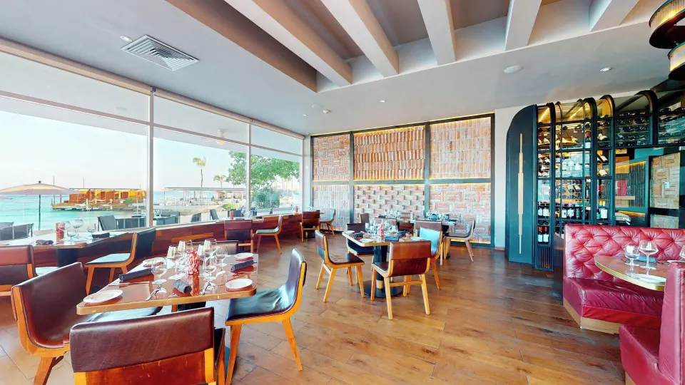 Indoor restaurant dining room with leather seating and ocean views at InterContinental Presidente Cozumel Resort Spa