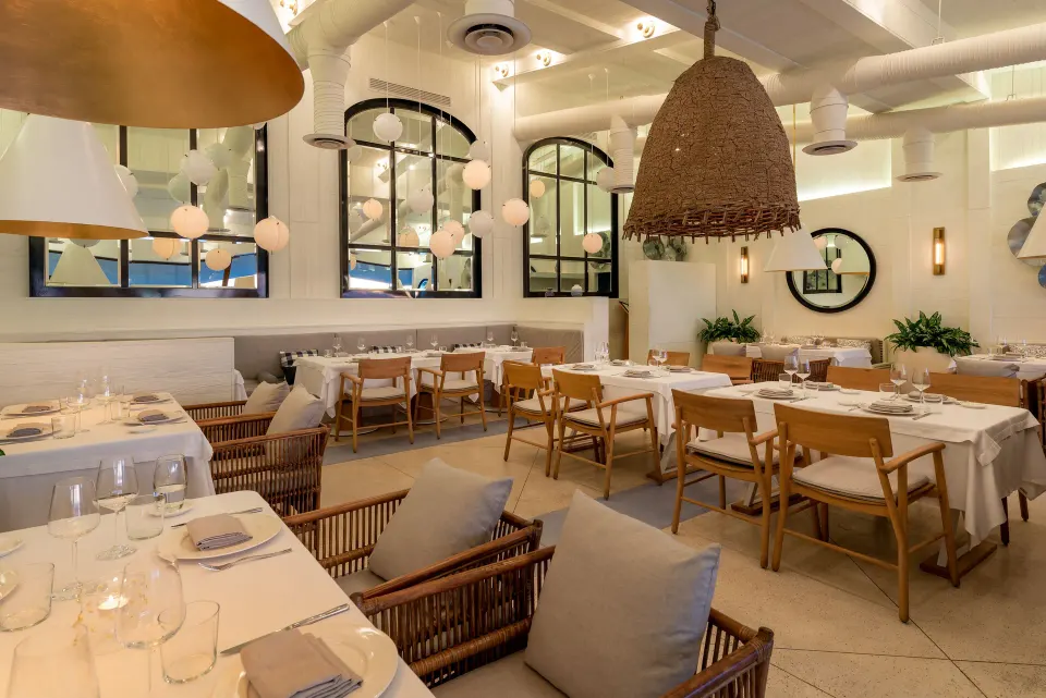 Outdoor restaurant terrace with white tables and wooden deck overlooking the ocean at InterContinental Presidente Cozumel Res