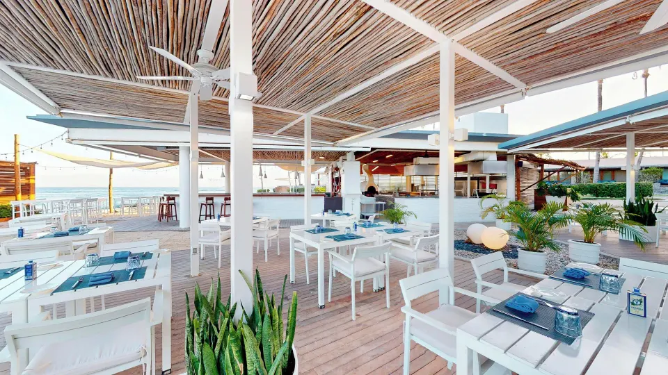 Bright white open-air restaurant seating on wooden deck at InterContinental Presidente Cozumel Resort Spa