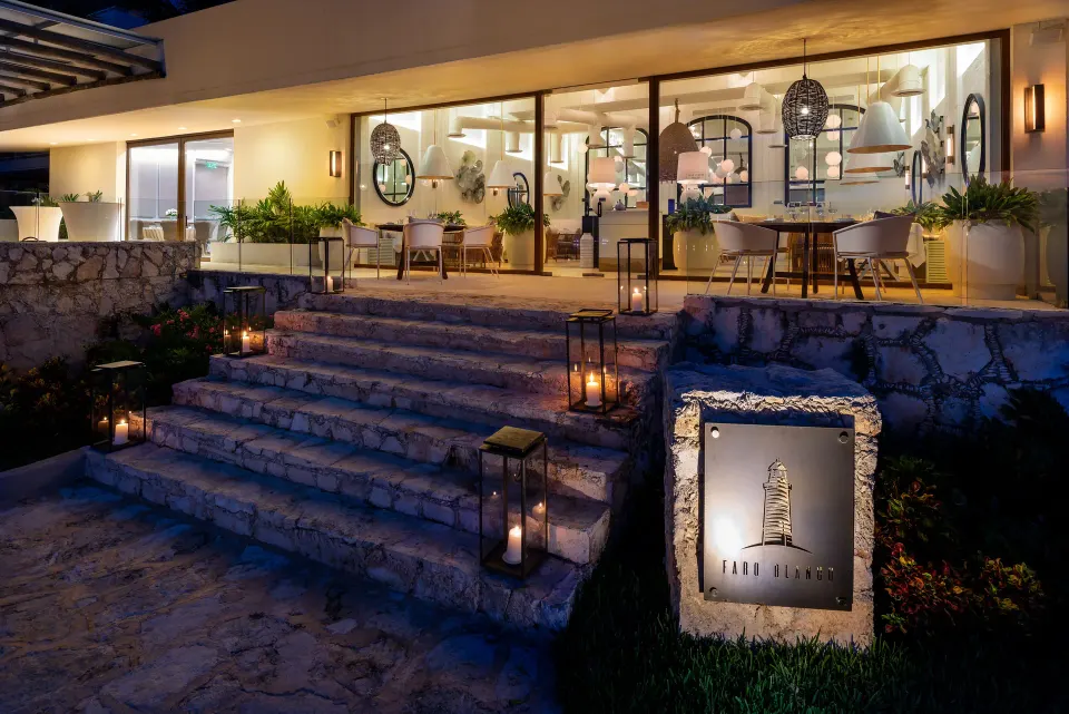 Stone steps leading to an evening restaurant entrance with a sign at InterContinental Presidente Cozumel Resort Spa