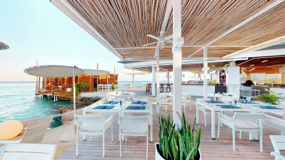 White open-air seaside dining tables on wooden deck at InterContinental Presidente Cozumel Resort Spa