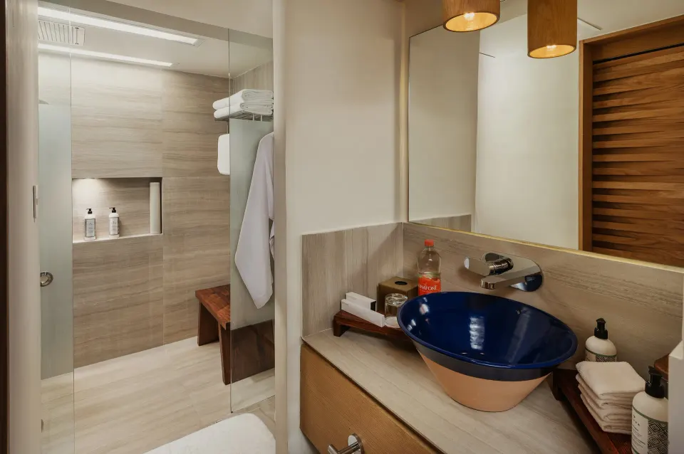 Bathroom vanity with blue vessel sink and shower in a Classic Room at InterContinental Presidente Cozumel Resort Spa