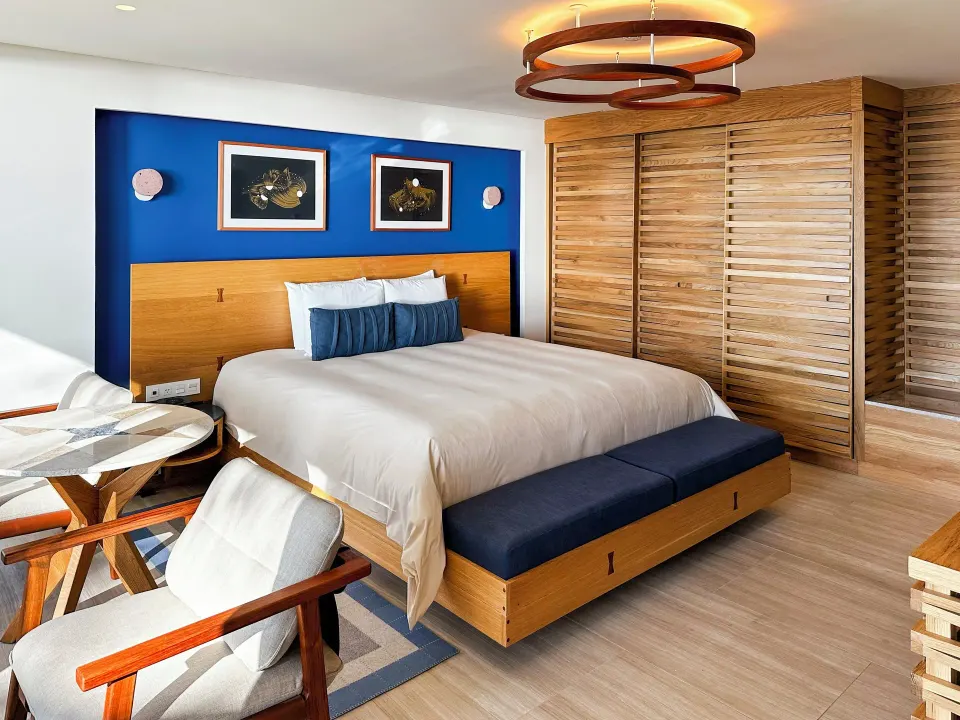 King bed with blue accent wall and paired artwork in a Classic Room at InterContinental Presidente Cozumel Resort Spa