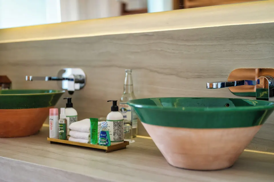 Close-up of ceramic green vessel sinks and toiletry tray in the Classic Room bathroom at InterContinental Presidente Cozumel 