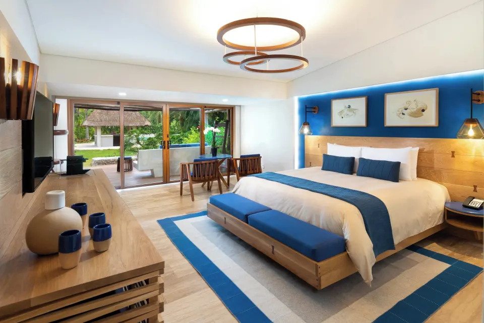 Classic Room king bed and media console with view through sliding doors to the resort grounds at InterContinental Presidente 