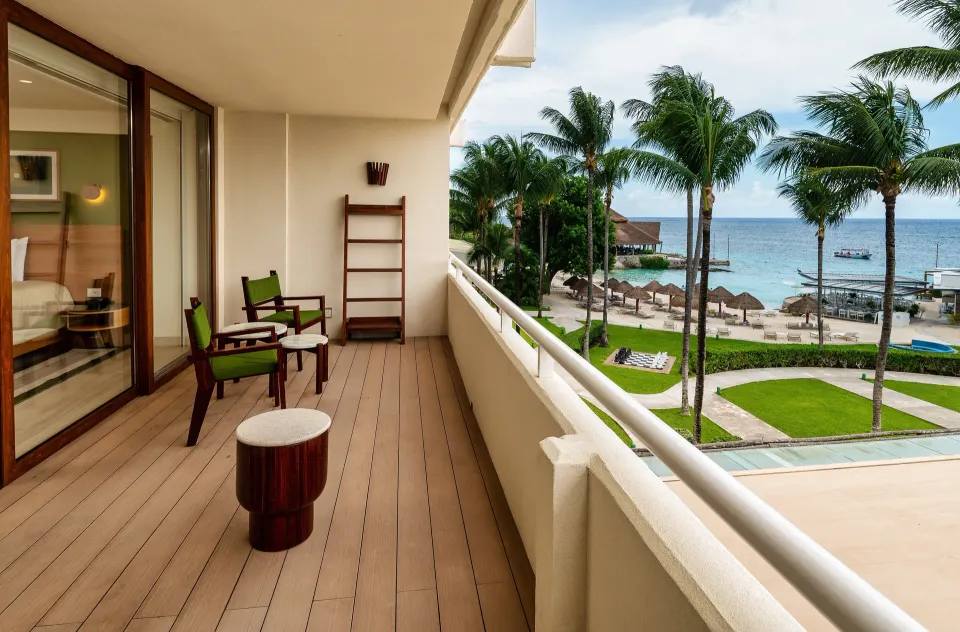 Balcony with chairs overlooking palms and the sea at InterContinental Presidente Cozumel Resort Spa