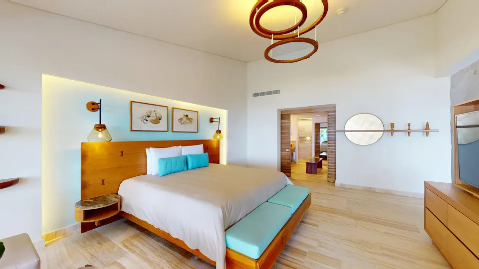 Contemporary junior suite bedroom with king bed and pendant light at InterContinental Presidente Cozumel Resort Spa