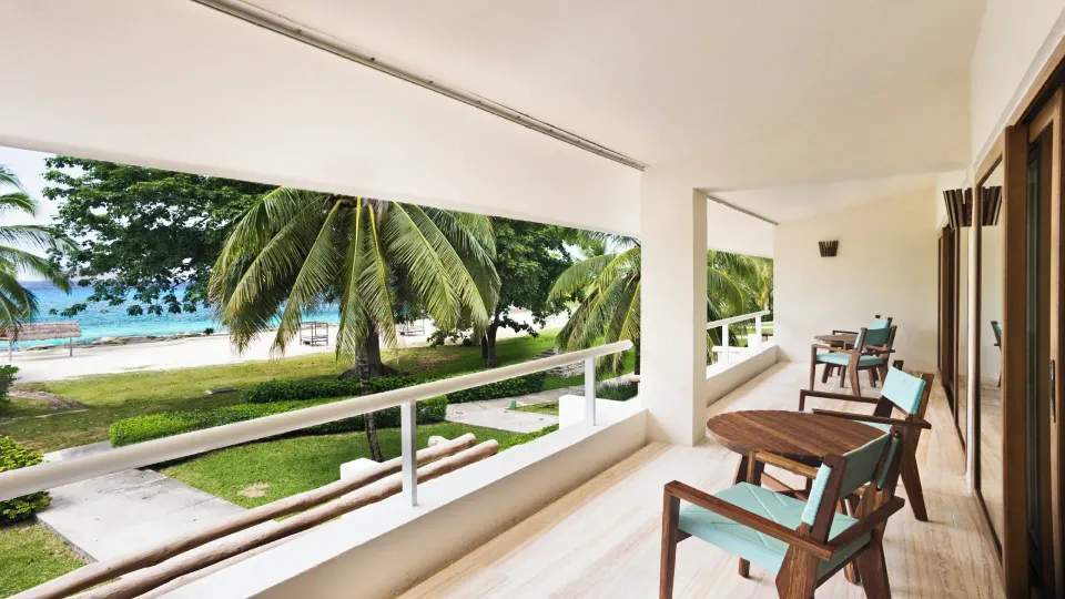 Covered junior suite balcony with two chairs and ocean view at InterContinental Presidente Cozumel Resort Spa