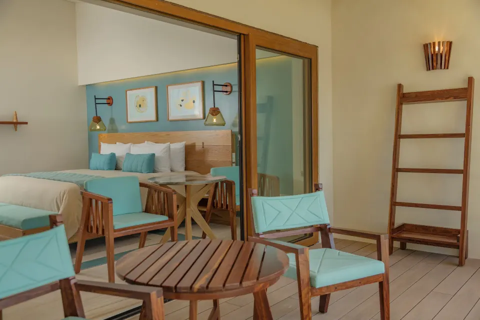 Balcony seating with round table and teak chairs looking into the premium room at InterContinental Presidente Cozumel Resort 