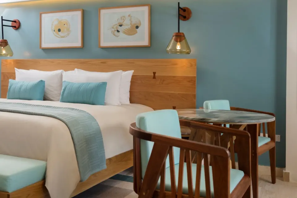 King bed with turquoise accents and dining table in Premium Ocean View room at InterContinental Presidente Cozumel Resort Spa