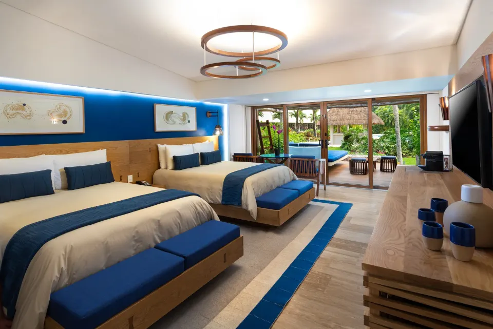 Interior view of a Premium Room Pool Access with two beds and patio doors at InterContinental Presidente Cozumel Resort Spa