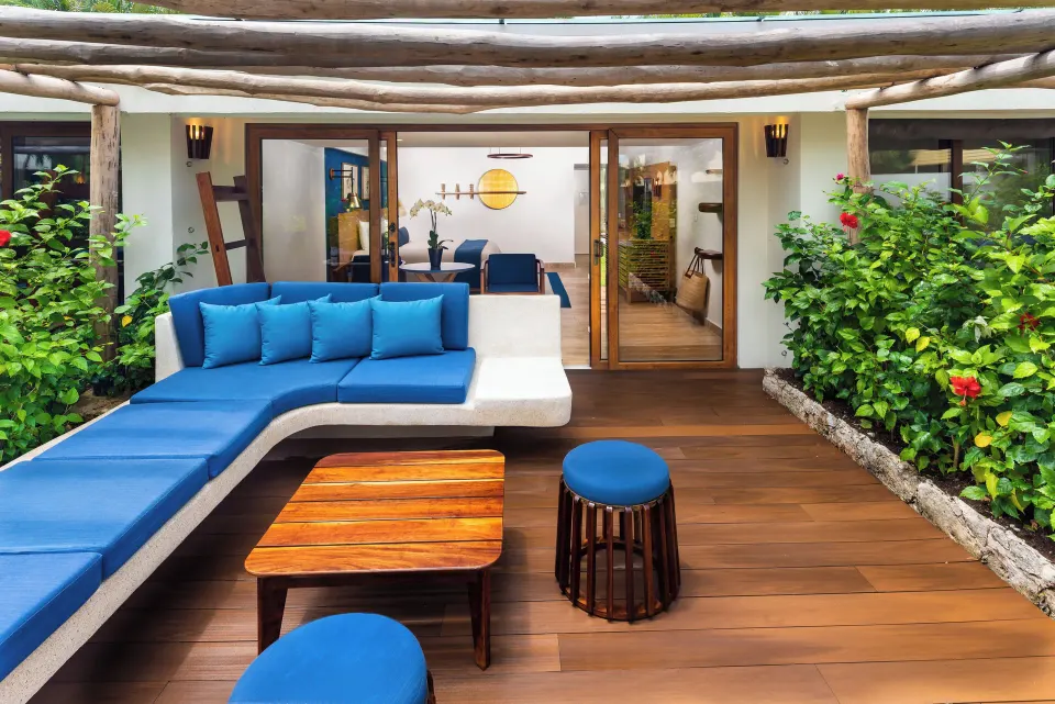 Wooden patio with L-shaped blue sofa outside a Premium Pool Access room at InterContinental Presidente Cozumel Resort Spa
