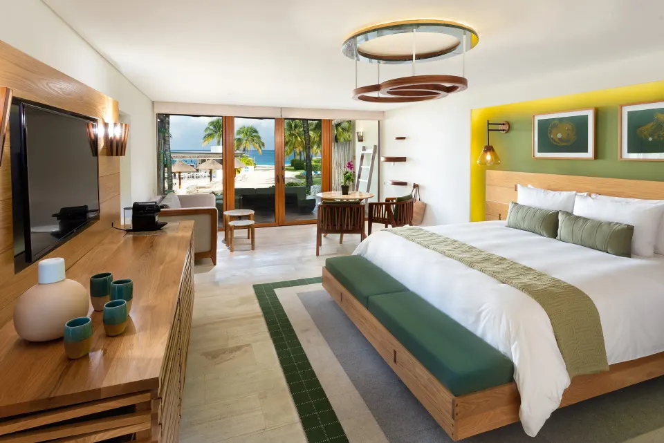 King bed with desk and patio doors opening to the beach at InterContinental Presidente Cozumel Resort Spa