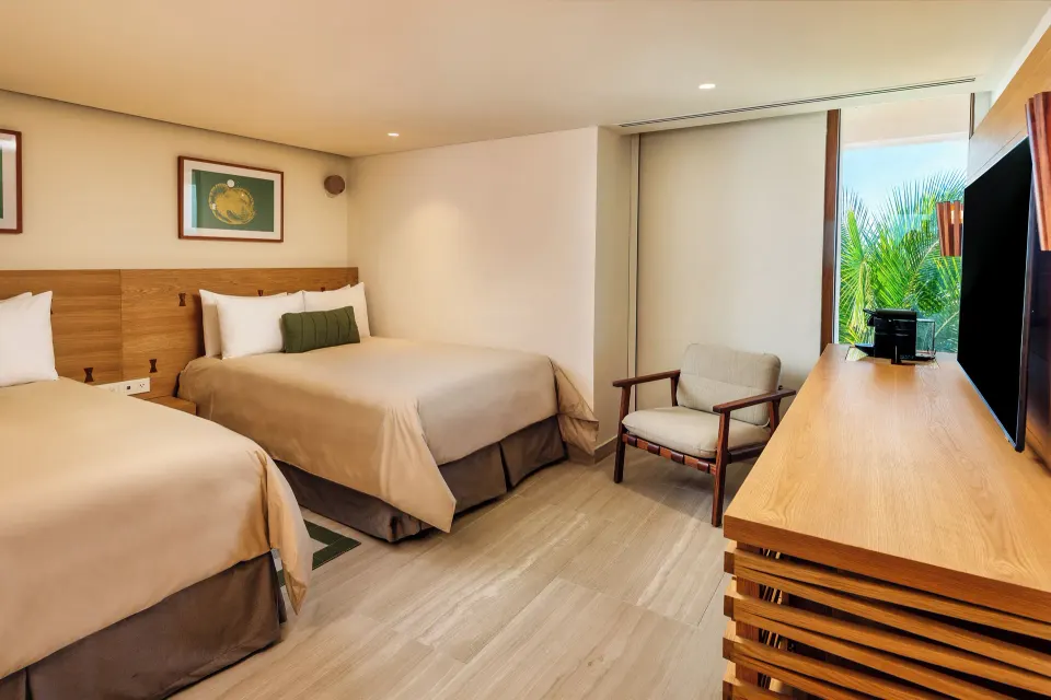 Cozy bedroom corner with two double beds and TV at InterContinental Presidente Cozumel Resort Spa