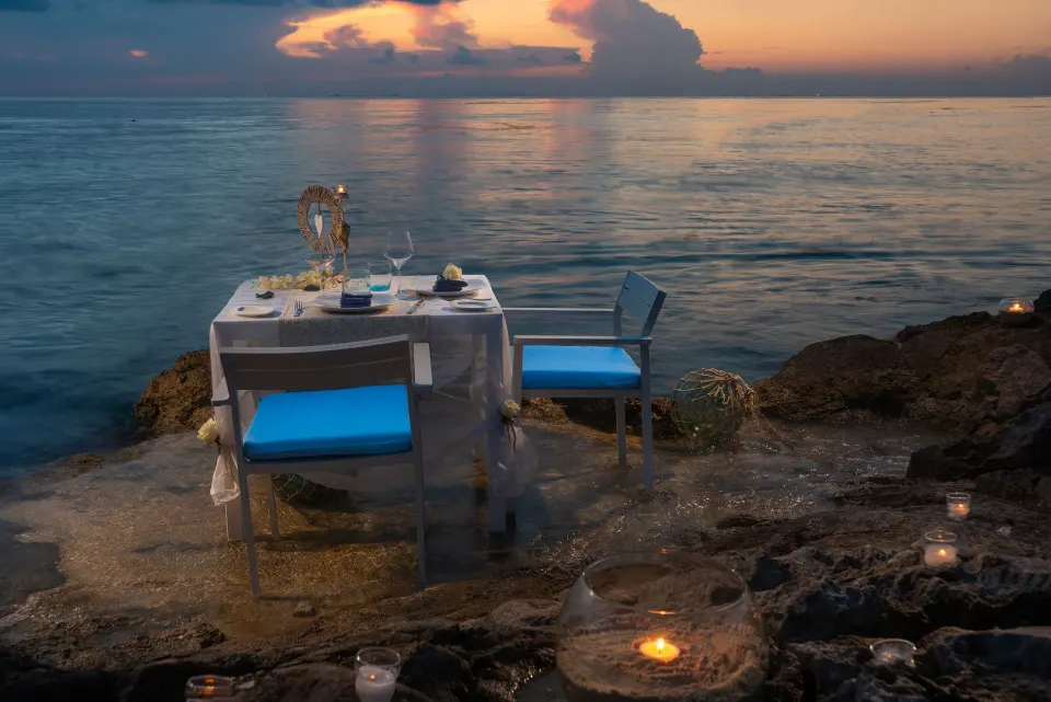 Candlelit table on rocky shoreline at sunset at InterContinental Presidente Cozumel Resort Spa