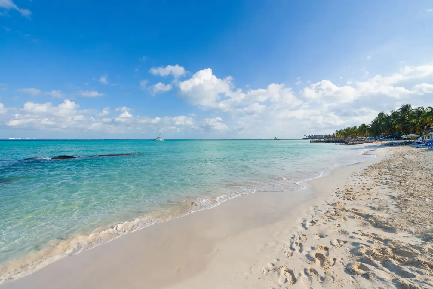 Curving beach with clear turquoise surf near Ixchel Beach Hotel.