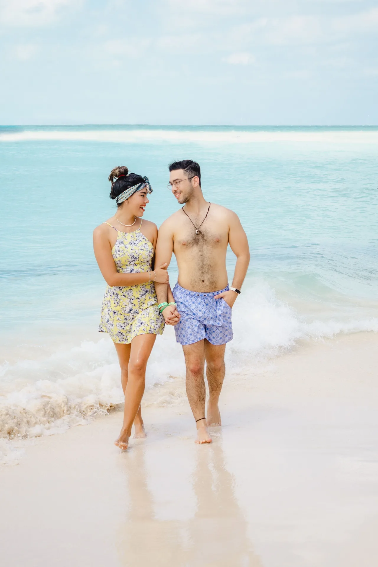 A couple walks hand in hand along the beach at Ixchel Beach Hotel.