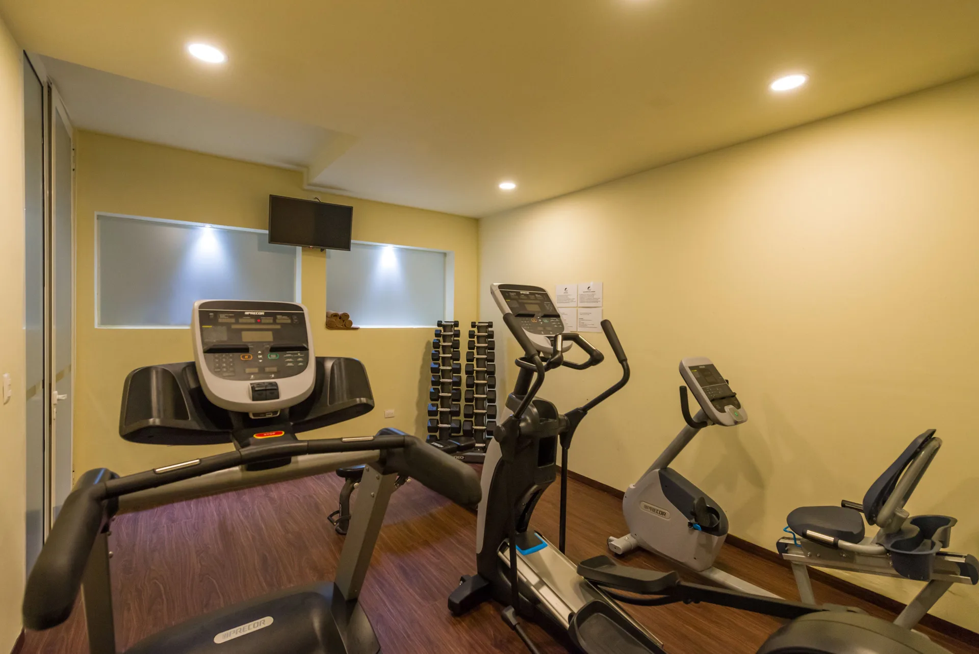 Cardio machines and dumbbells fill the fitness room at Ixchel Beach Hotel.