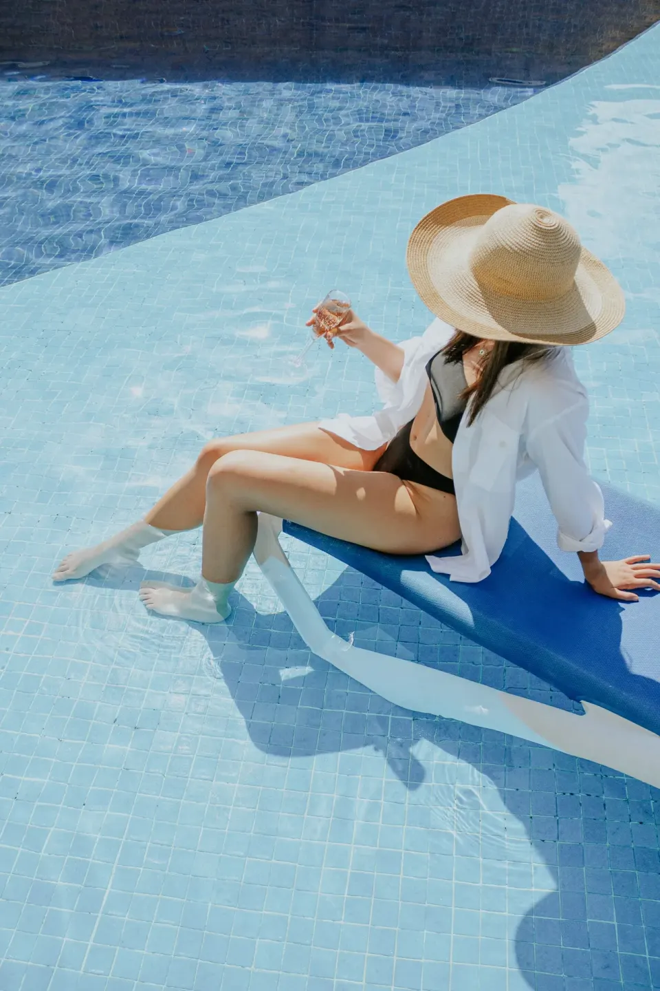 A guest sits on an in-water lounge chair in the pool at Ixchel Beach Hotel.