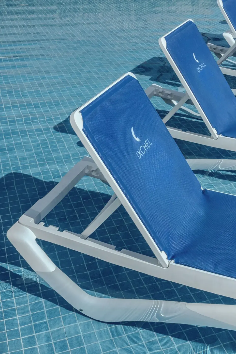 Close-up of blue in-water pool loungers at Ixchel Beach Hotel.
