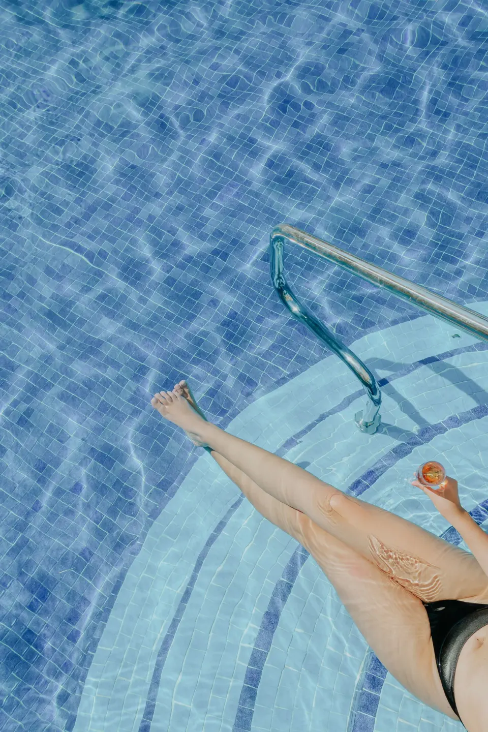 A guest lounges on submerged pool steps at Ixchel Beach Hotel.