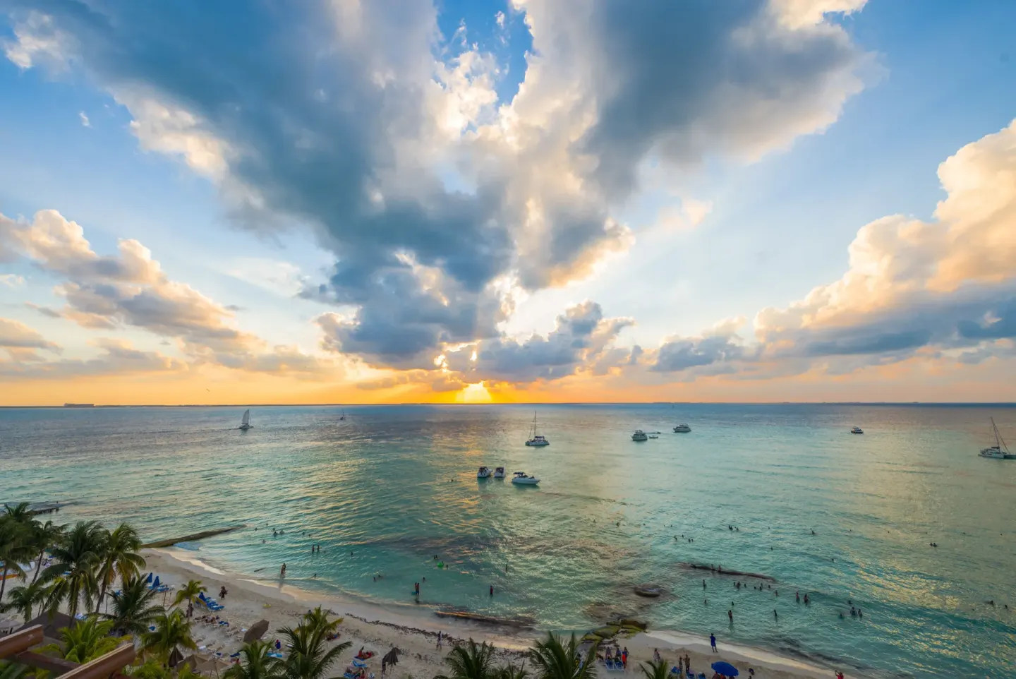 Sunset over the beach and anchored boats at Ixchel Beach Hotel.