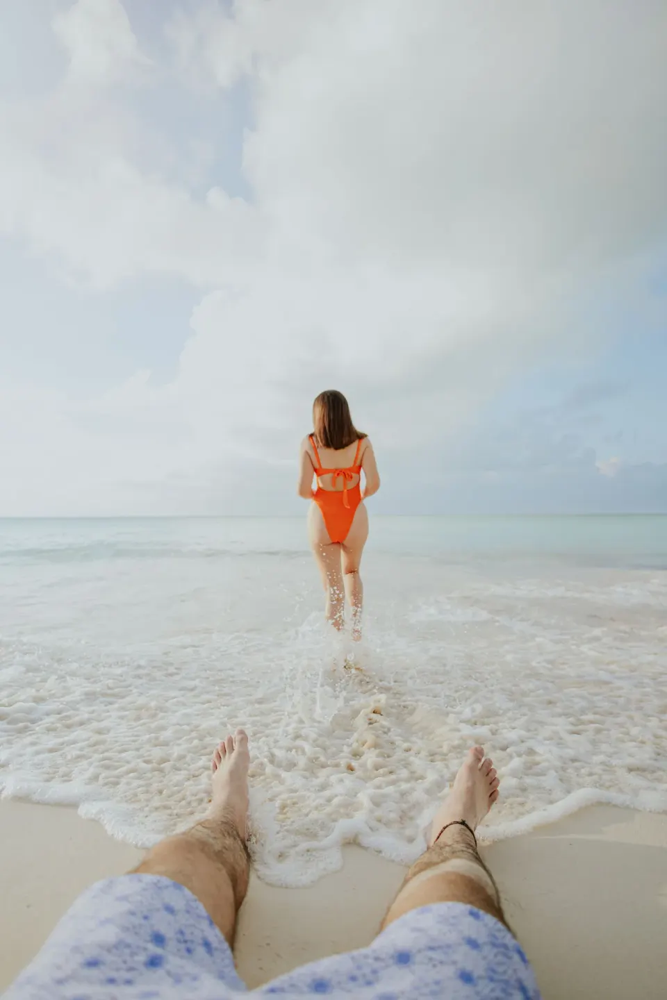A guest wades into foamy surf on the beach at Ixchel Beach Hotel.