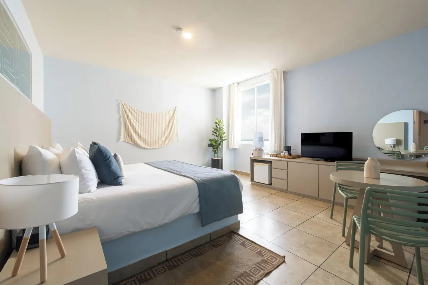Standard Room with a bed, dining table, TV, and window at Ixchel Beach Hotel.