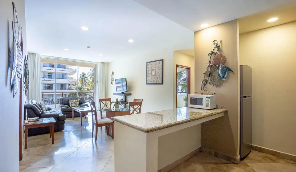 Kitchen counter, refrigerator, and lounge area in a beachfront suite at Ixchel Beach Hotel.