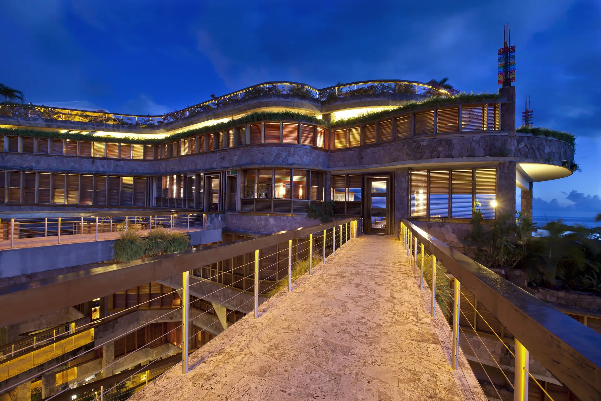 Illuminated resort building and raised walkway at dusk at Jade Mountain Resort.