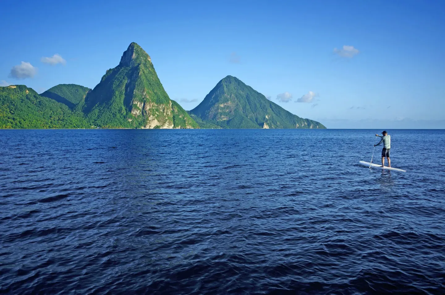 Paddleboarder on the sea with the Pitons in view near Jade Mountain Resort.