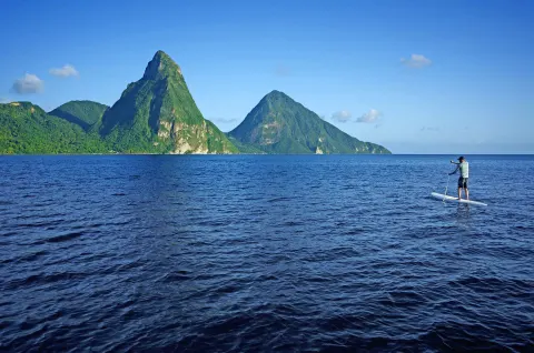Paddleboarder on the sea with the Pitons in view near Jade Mountain Resort.