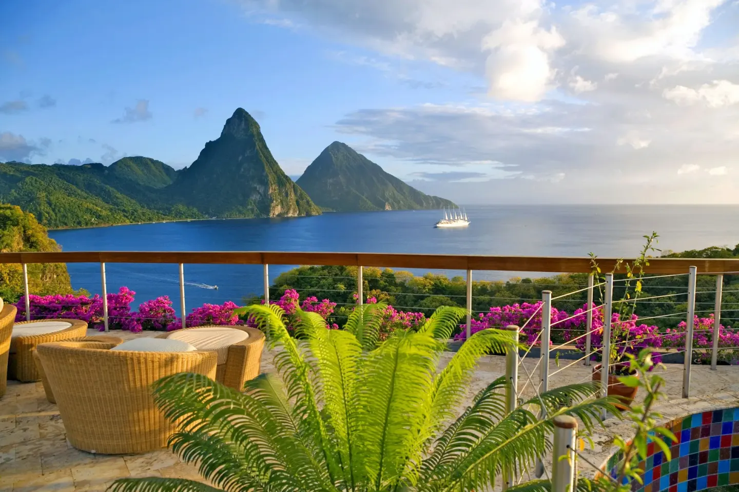 Terrace lounge seating with flowering railings and Piton views at Jade Mountain Resort.