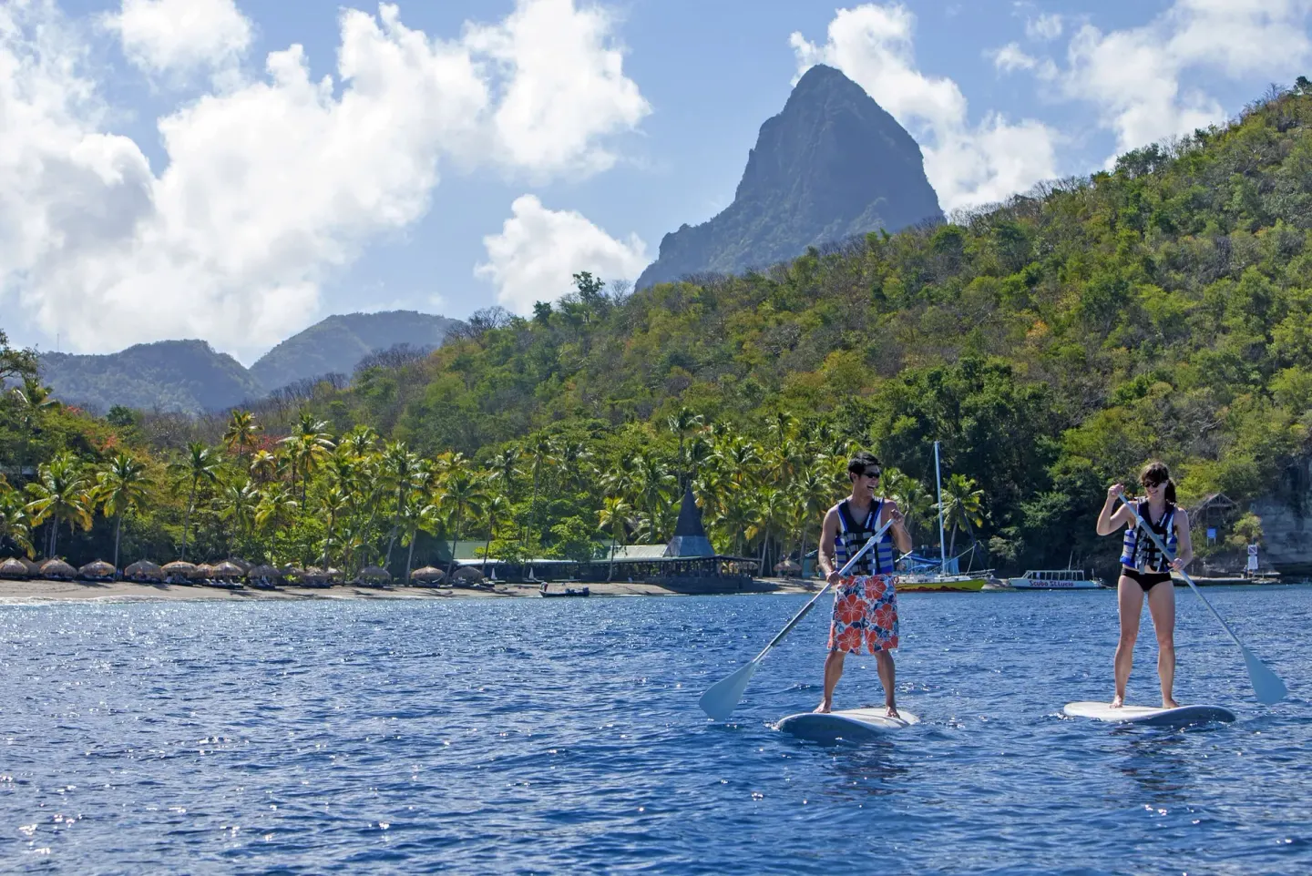 Guests paddleboard on the bay below the Pitons near Jade Mountain Resort.