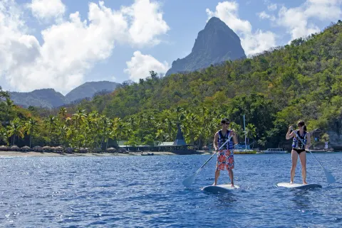 Guests paddleboard on the bay below the Pitons near Jade Mountain Resort.