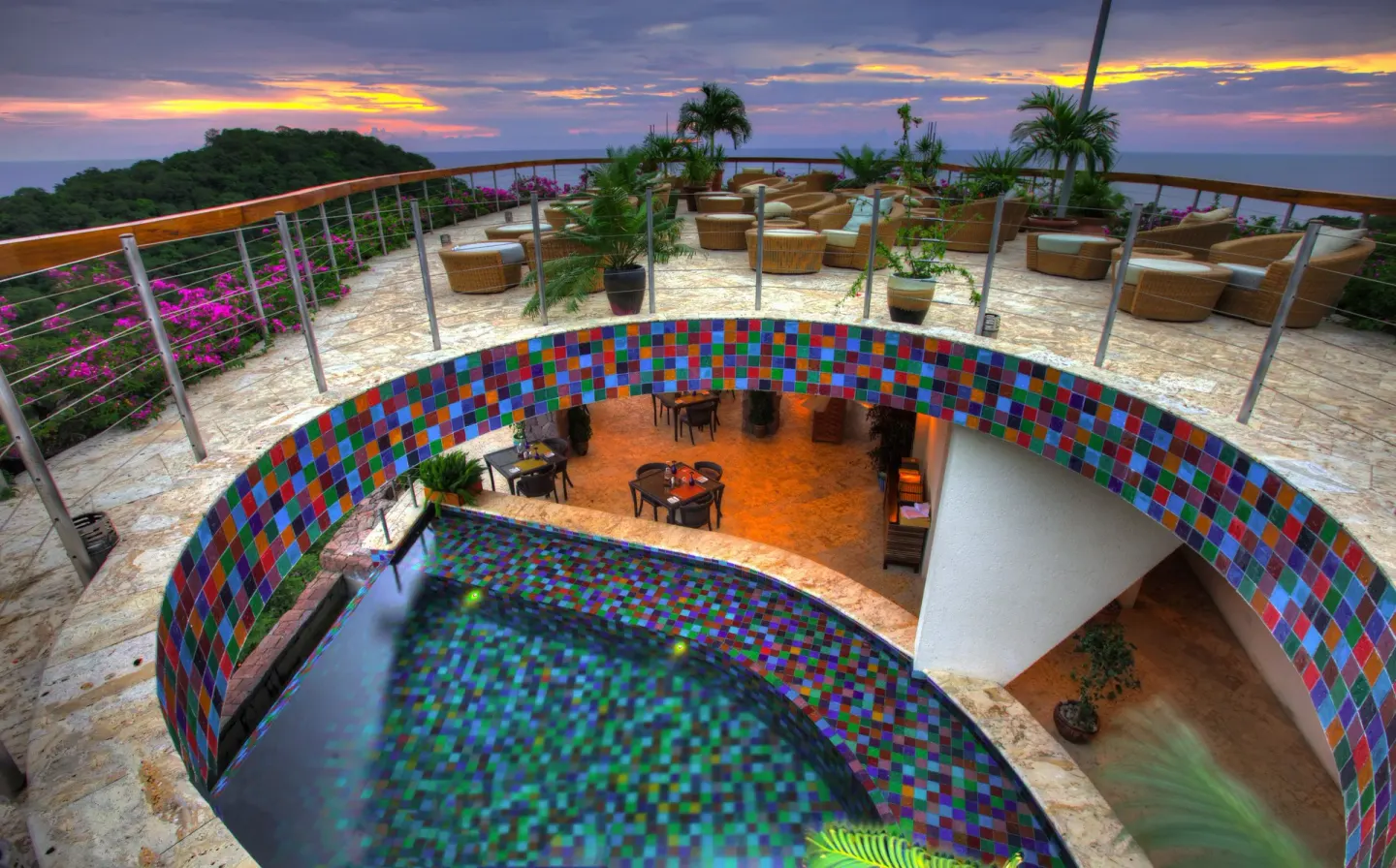 Curved tiled pool and rooftop terrace at sunset at Jade Mountain Resort.