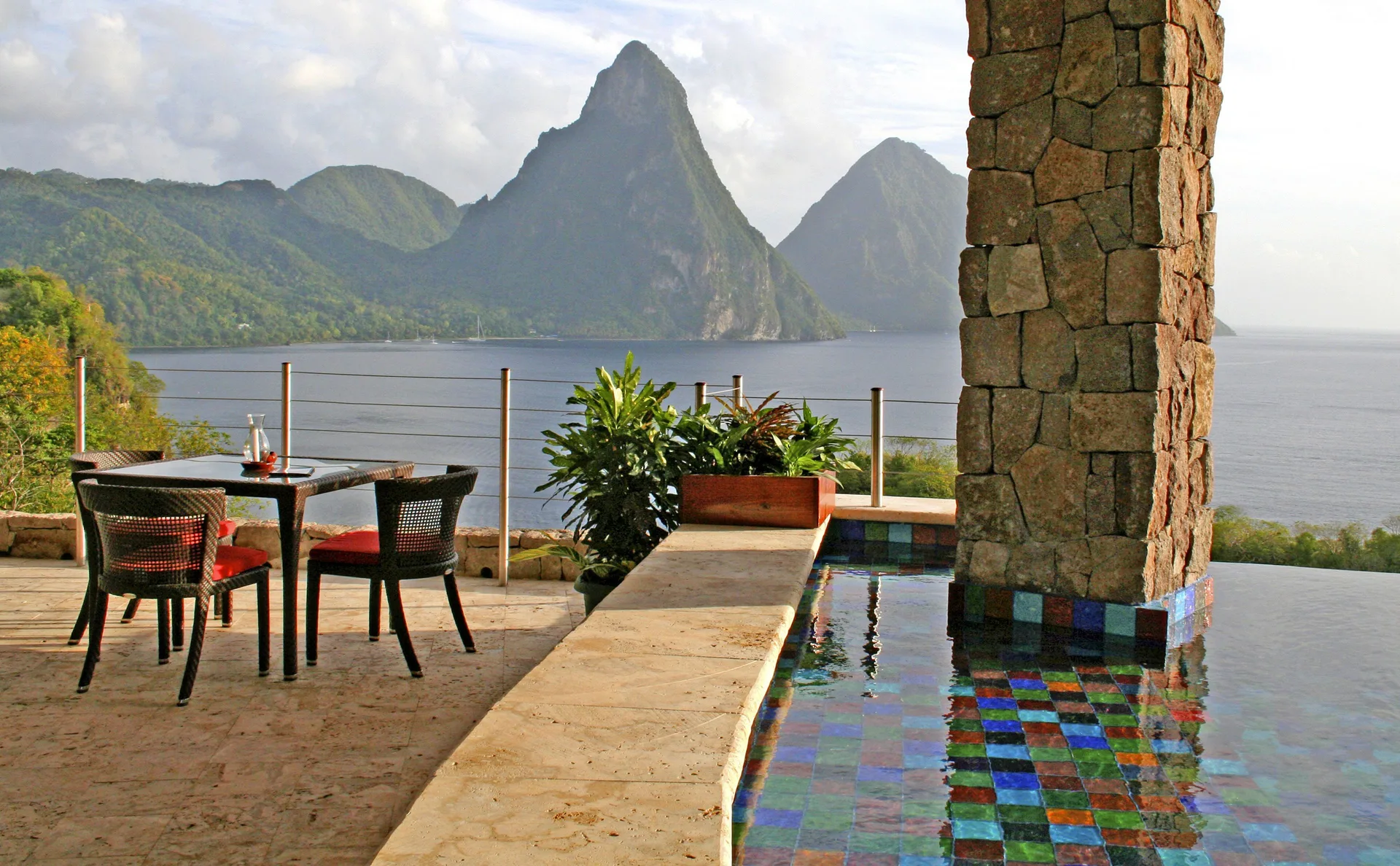 Terrace dining table beside an infinity pool with Piton views at Jade Mountain Resort.