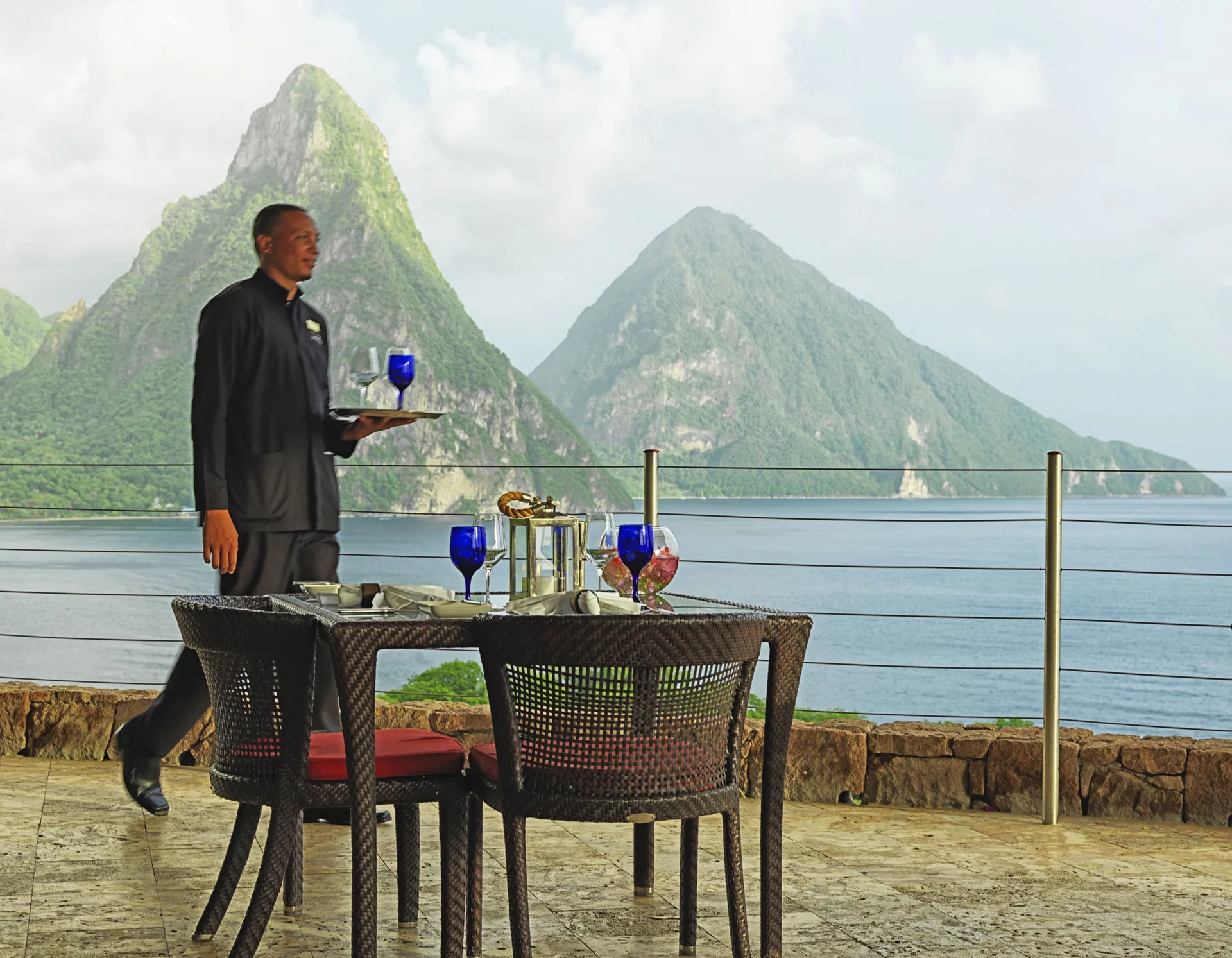 A waiter serves a terrace table with Piton views at Jade Mountain Resort.
