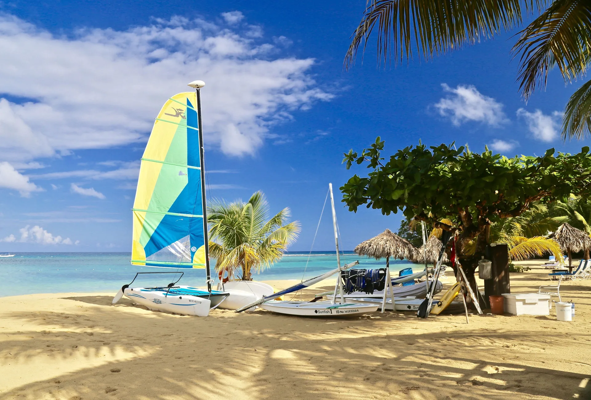 Small sailboats and beach equipment set on the sand at Jamaica Inn.
