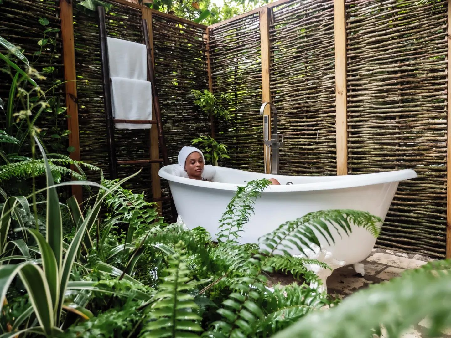 Outdoor clawfoot bathtub surrounded by greenery at Jamaica Inn.