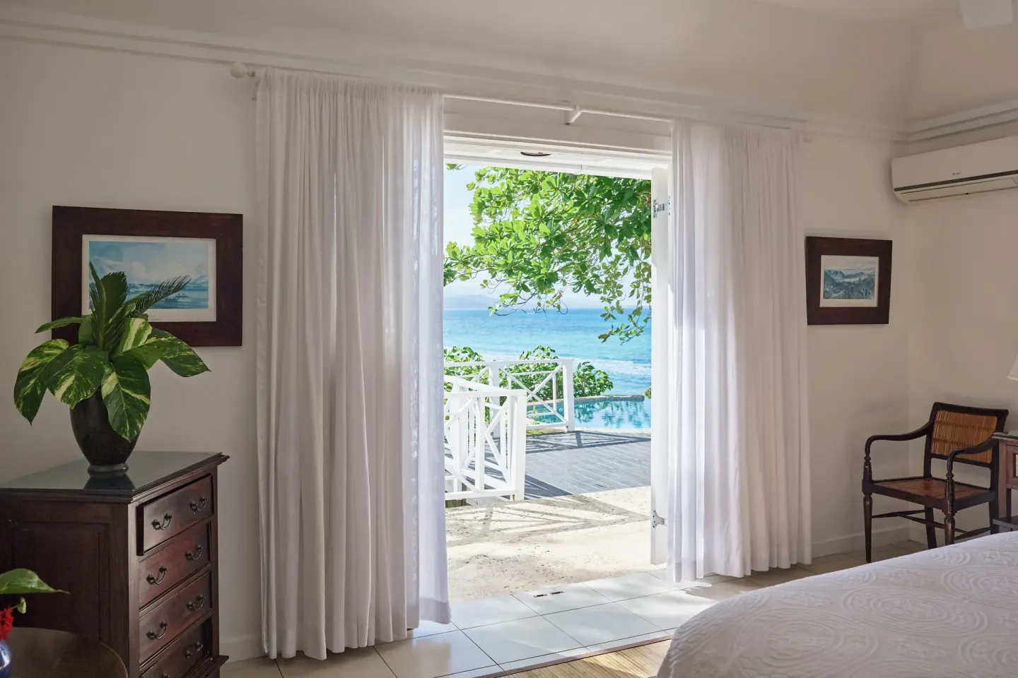 Guest room doorway with white curtains opening to the sea at Jamaica Inn.