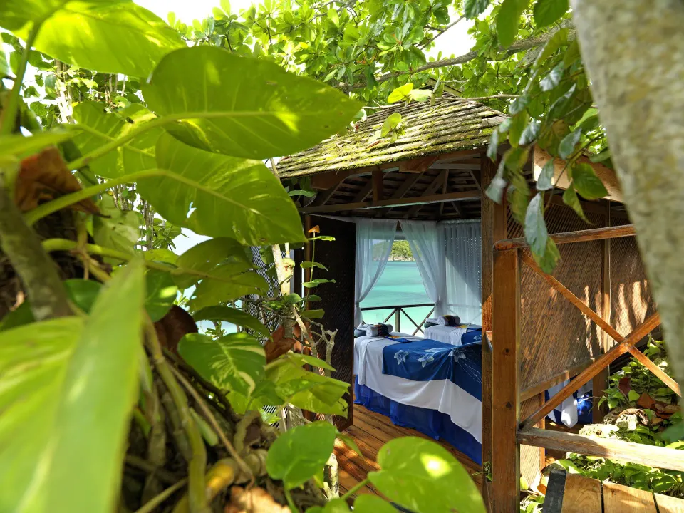 Spa pavilion glimpsed through tropical leaves at Jamaica Inn.