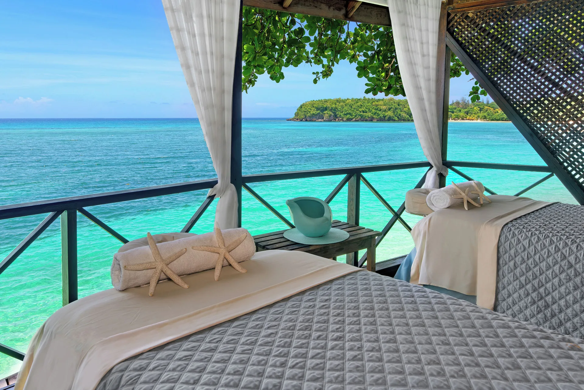 Two spa treatment beds on an overwater deck at Jamaica Inn.