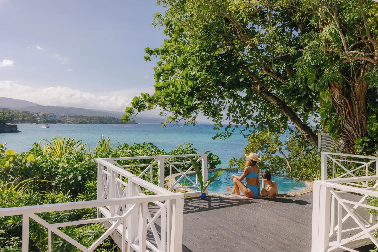 Pool deck with white railings and sea view at Jamaica Inn.