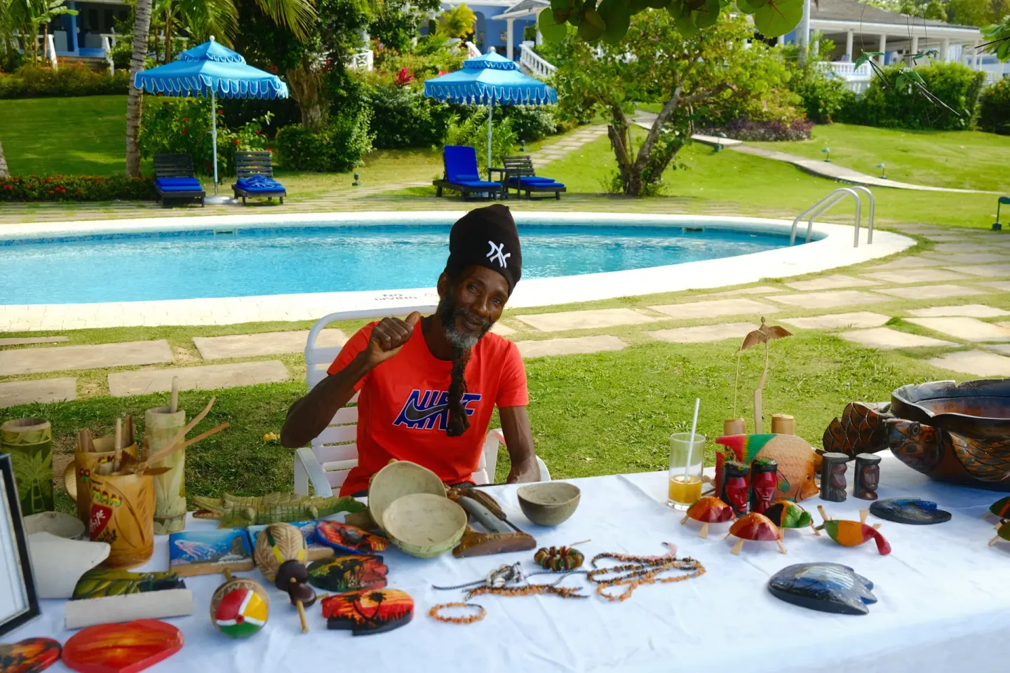An artisan displays handmade crafts beside the pool at Jamaica Inn.