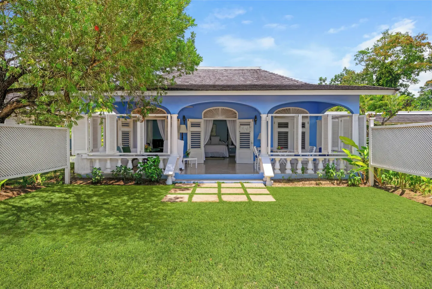 Blue Cottage exterior with lawn, verandas, and open shutters at Jamaica Inn.