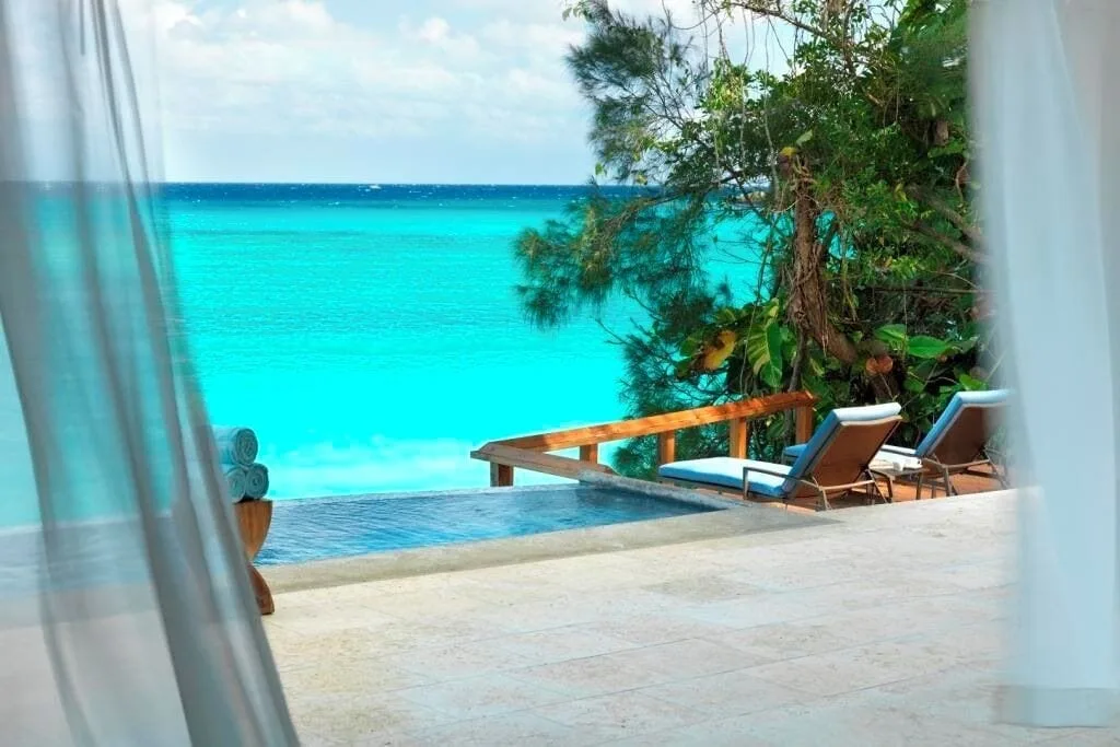 Cottage Seven terrace with infinity pool, loungers, and ocean view at Jamaica Inn.